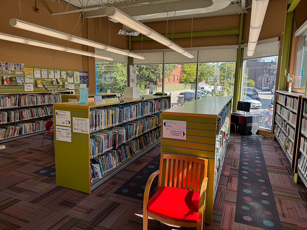 Children's section at Palmerston Library, with shelves of books and a window in the background.